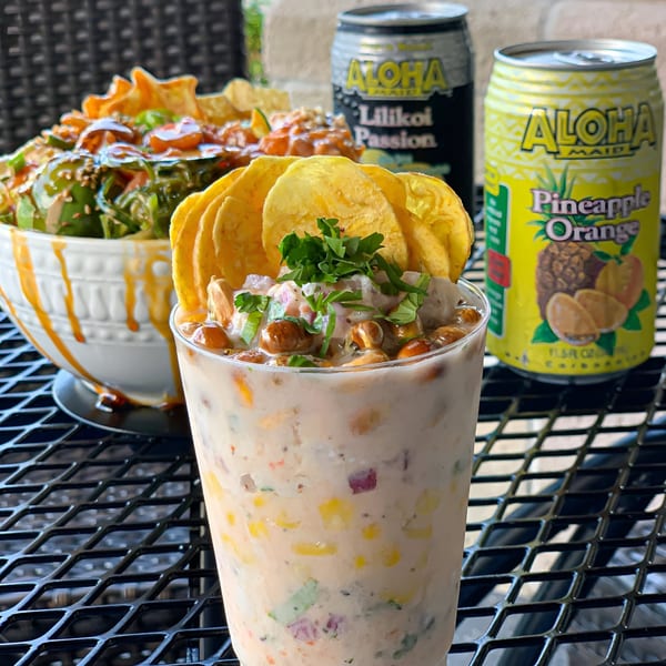 Poki Bowl Kendall's poke bowl, ceviche, and two Aloha Maid drinks on a black mesh table.
