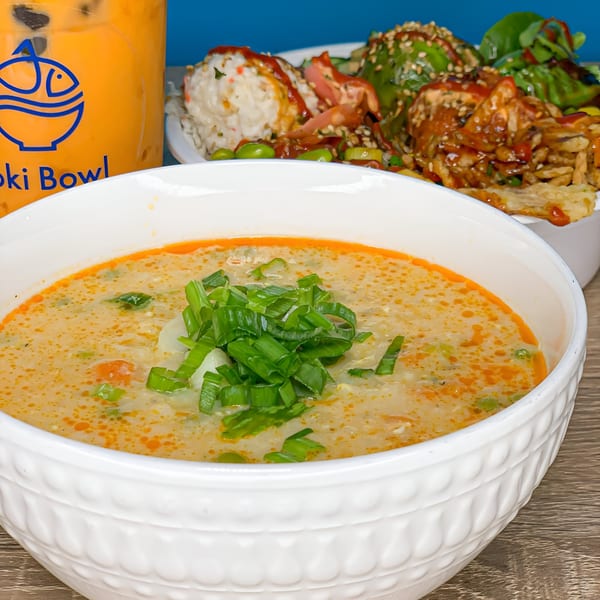 Creamy soup with green onions, a Poki Bowl drink, and poke bowls in the background.